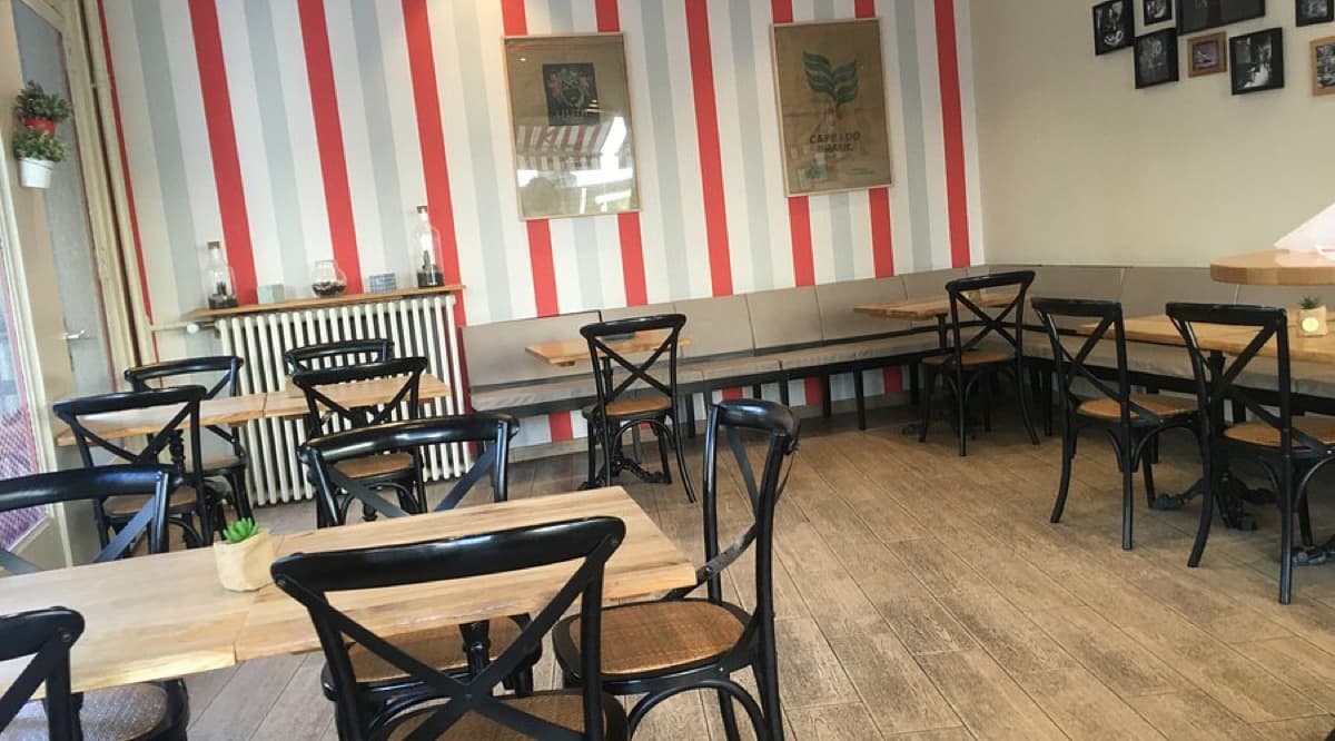 Salle du Coffee Lab : murs à rayures rouges, tables en bois et chaises bistrot, rue de la Servette.